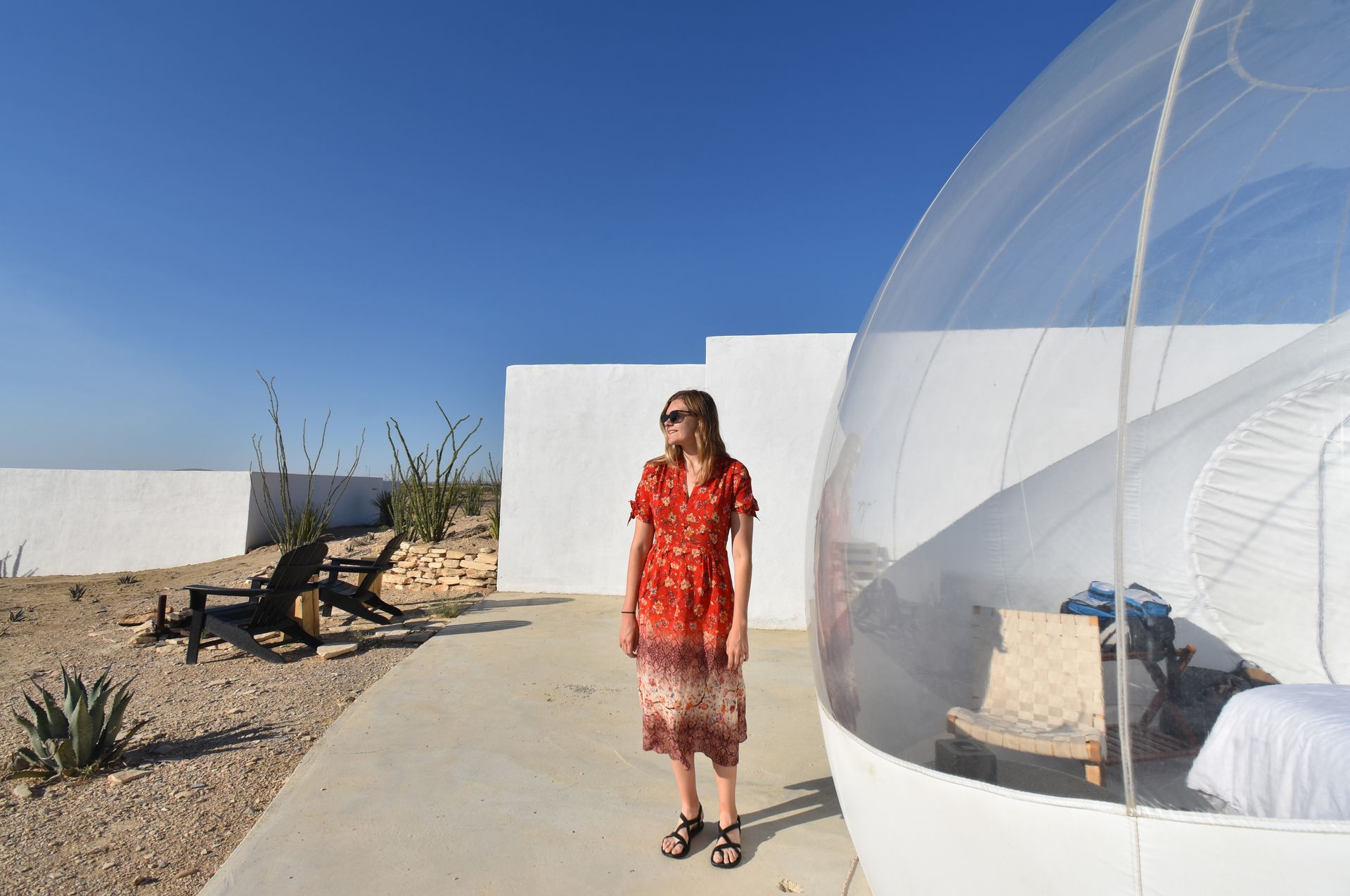 Lydia standing on a white platform next to a clear bubble.