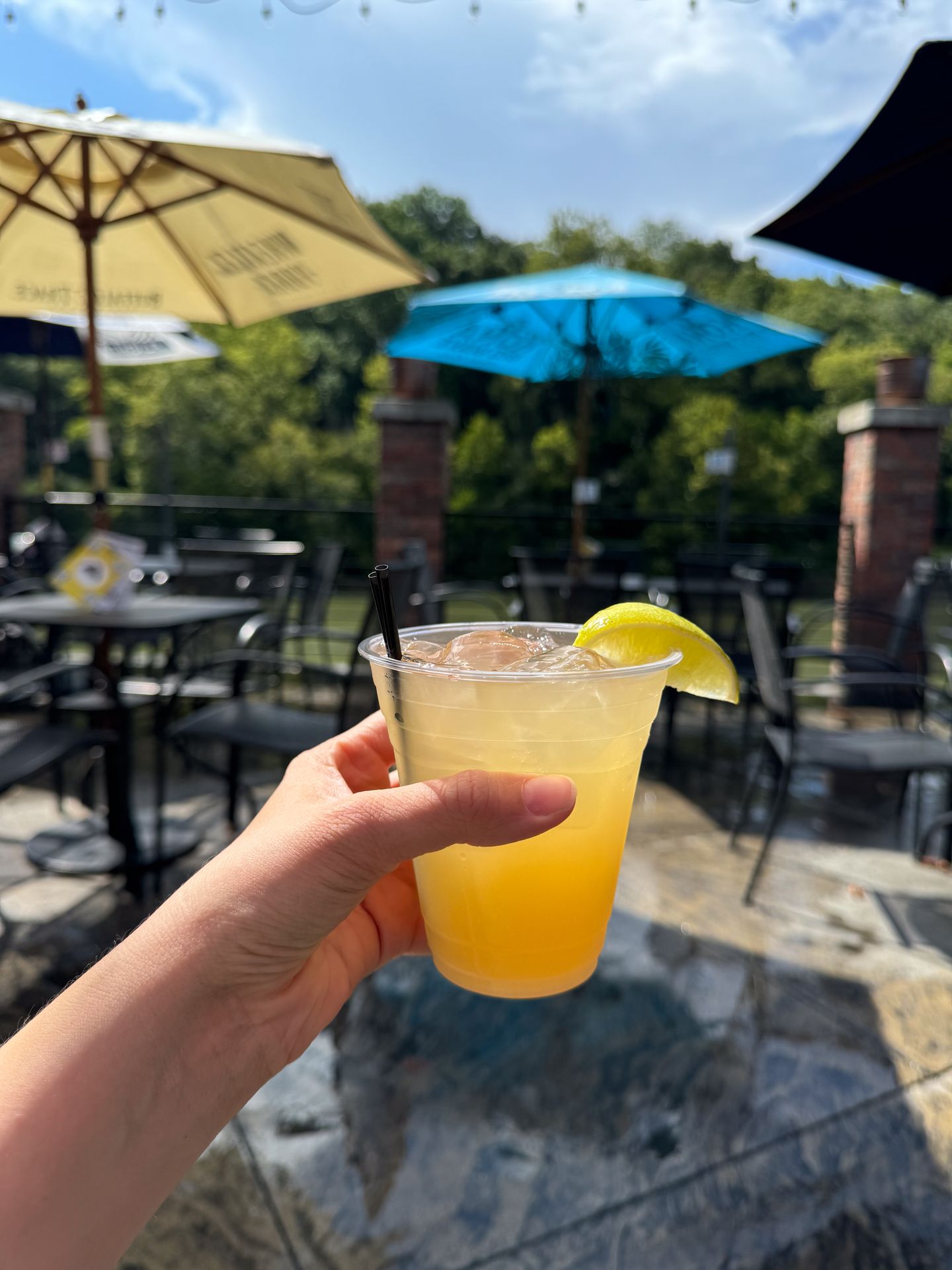 Holding up a yellow cocktail on the patio at Monkey Bar and Grille