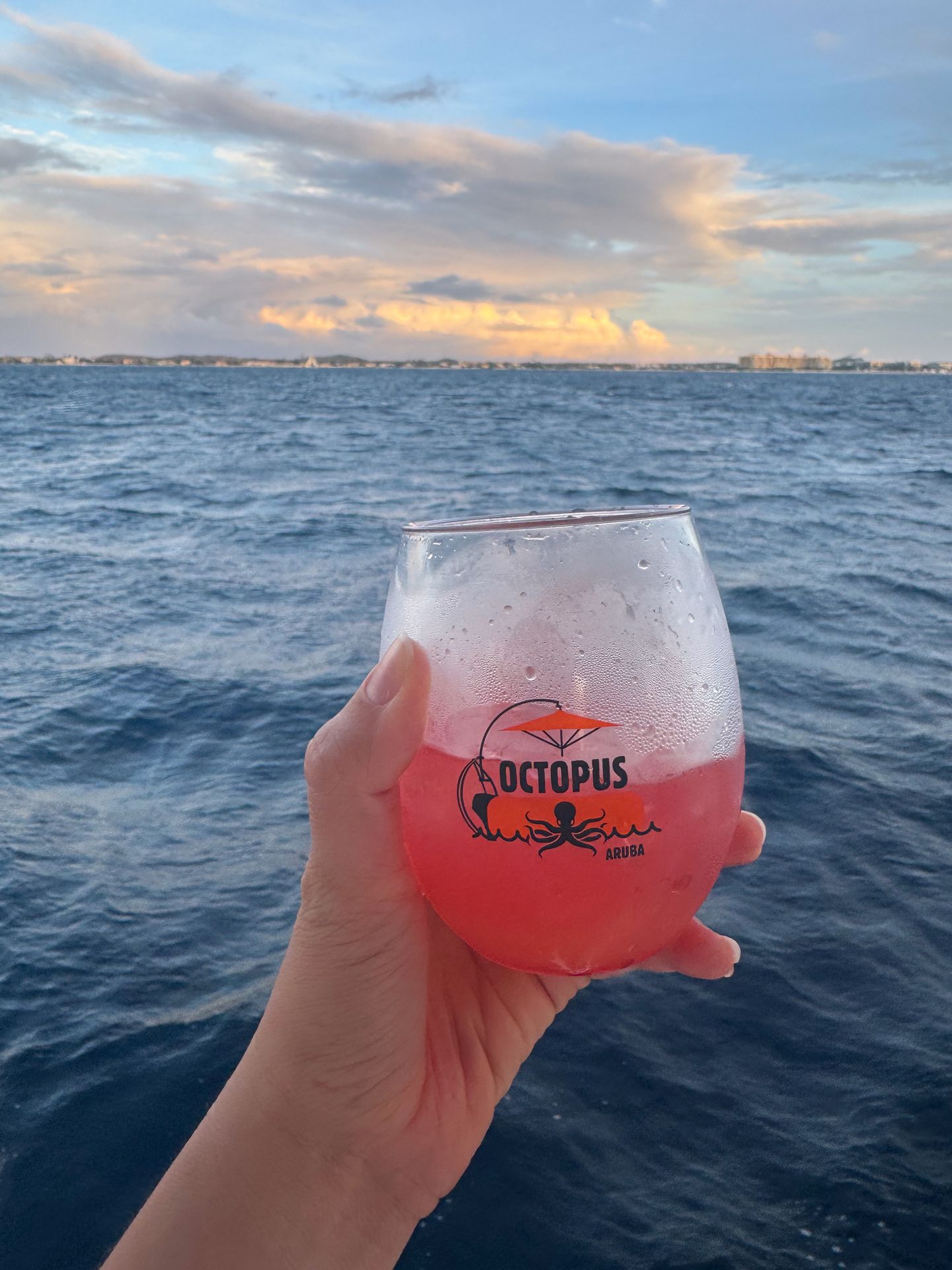 Holding up a red cocktail on board of a sunset sail