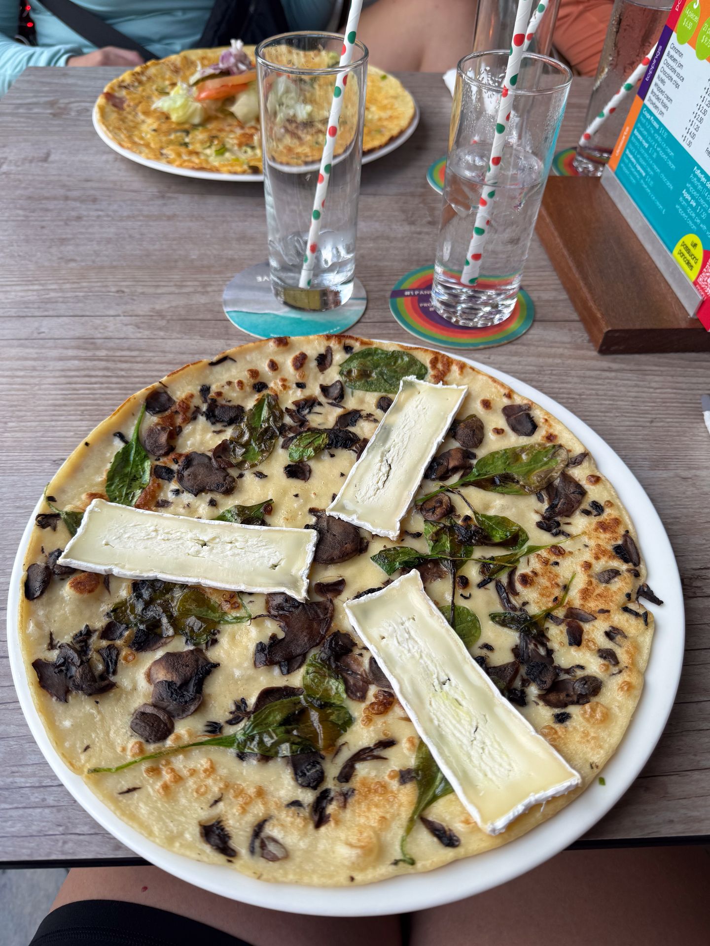 A large, thin pancake topped with brie, mushrooms and more