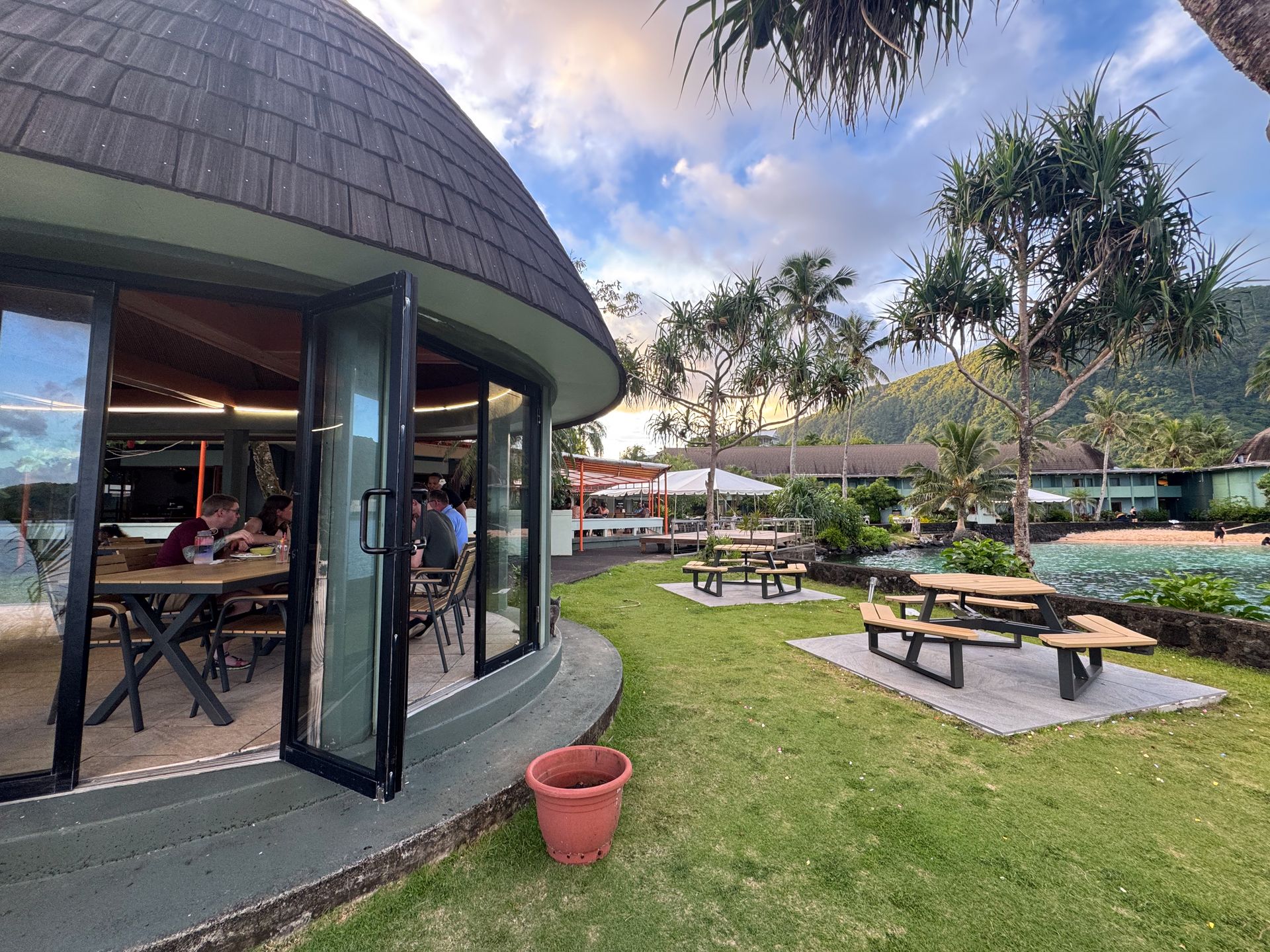 A lawn with picnic tables and an open air dining area on the coast