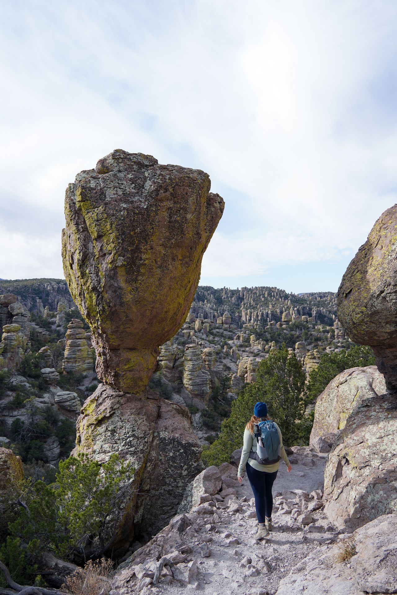 Lydia standing next to a huge balanced rock on the Echo Canyon trail in Chiricahua National Monument