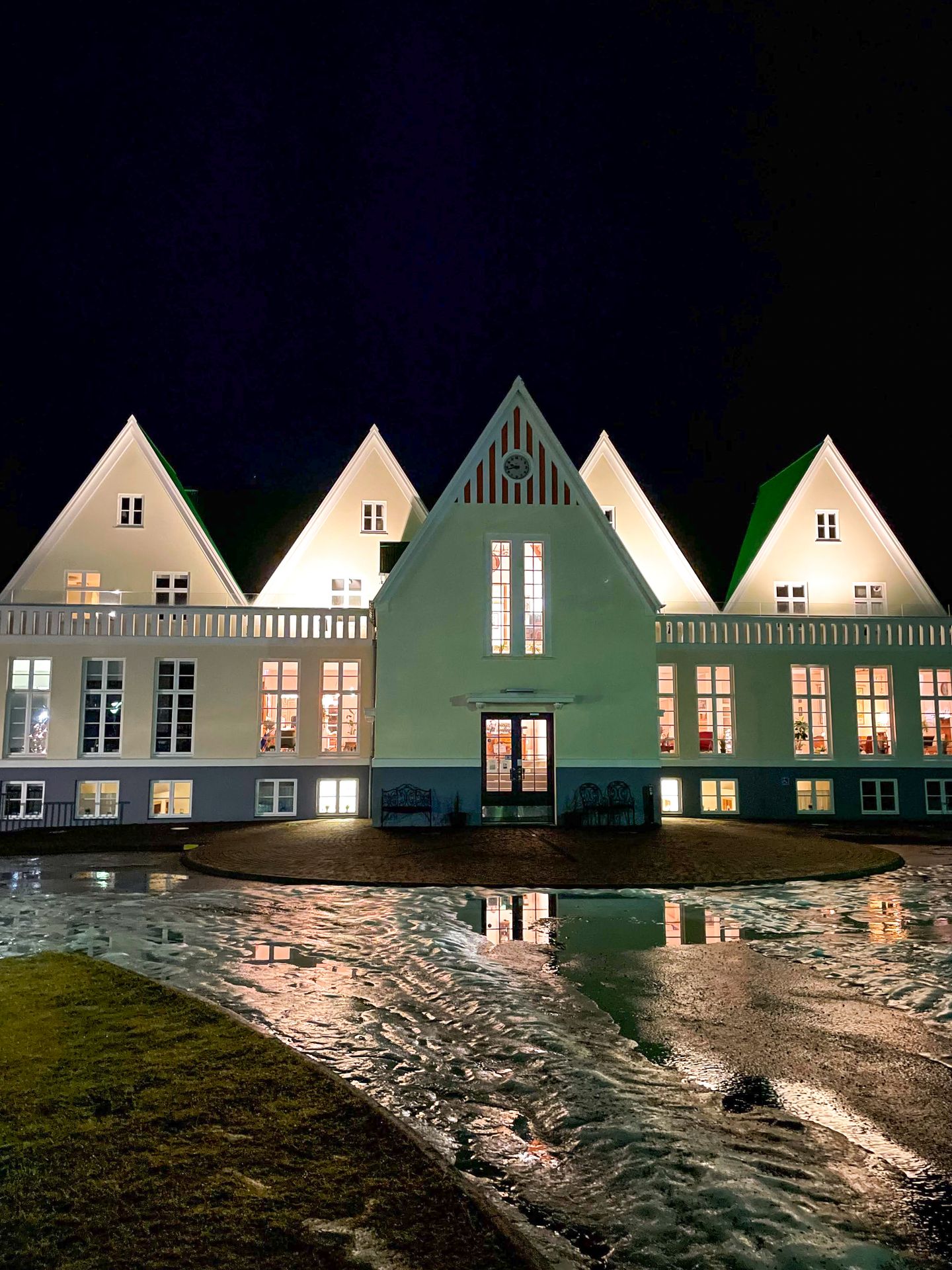 The exterior of Héraðsskólinn Historic Guesthouse, which resembled a guesthouse that is green and white.