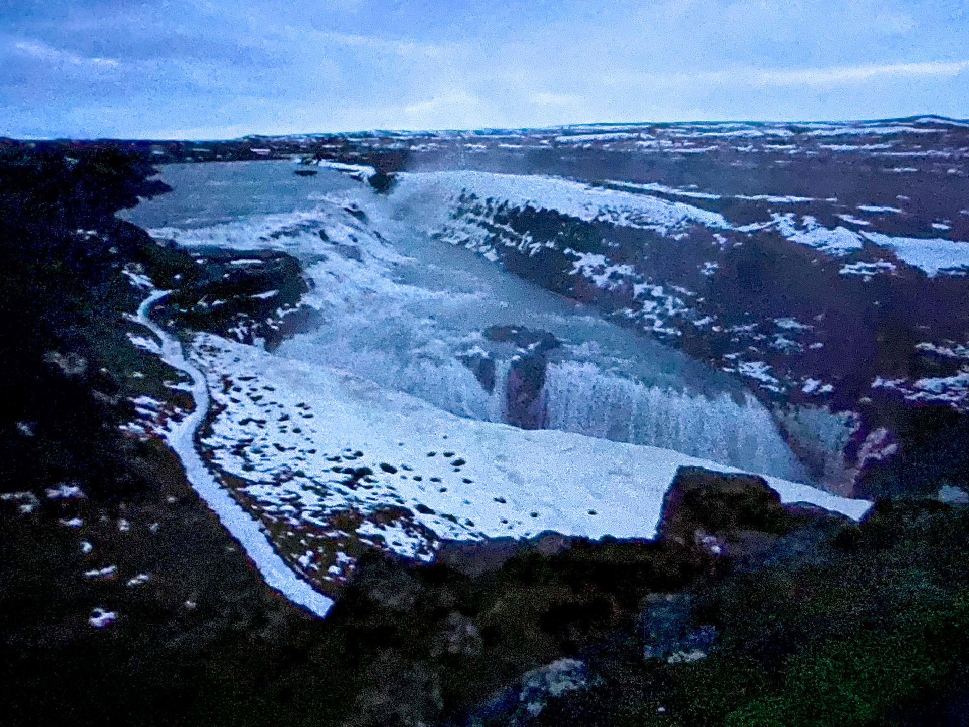 Looking down at a huge waterfall in dim lighting.