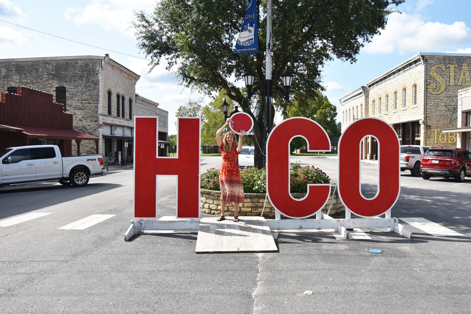 Lydia holding the dot of the i up in the word "Hico"