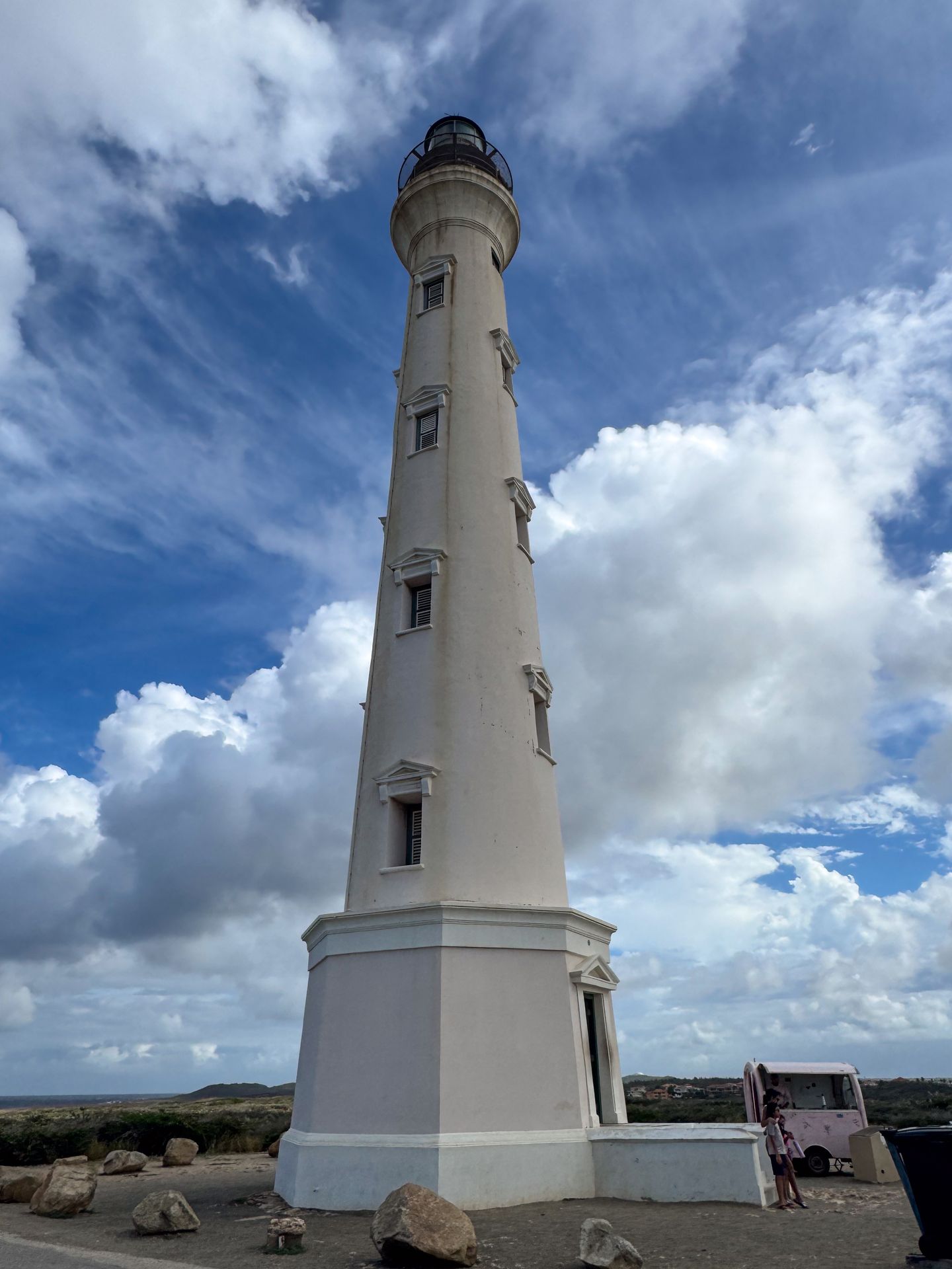 Looking up at a thin, white lighthouse