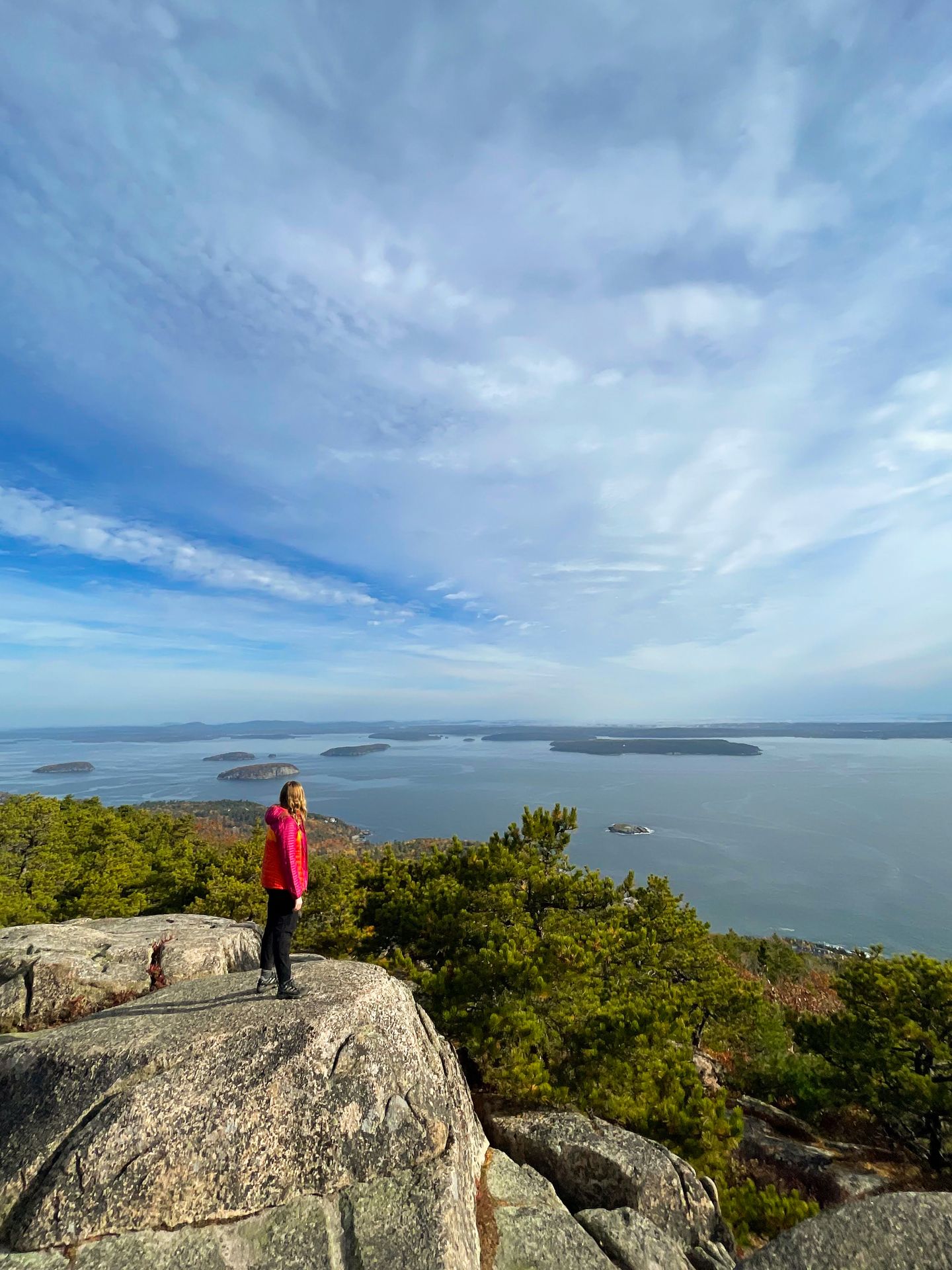 Lydia standing on a rock and looking out at the water from the top of the Precipice Trail