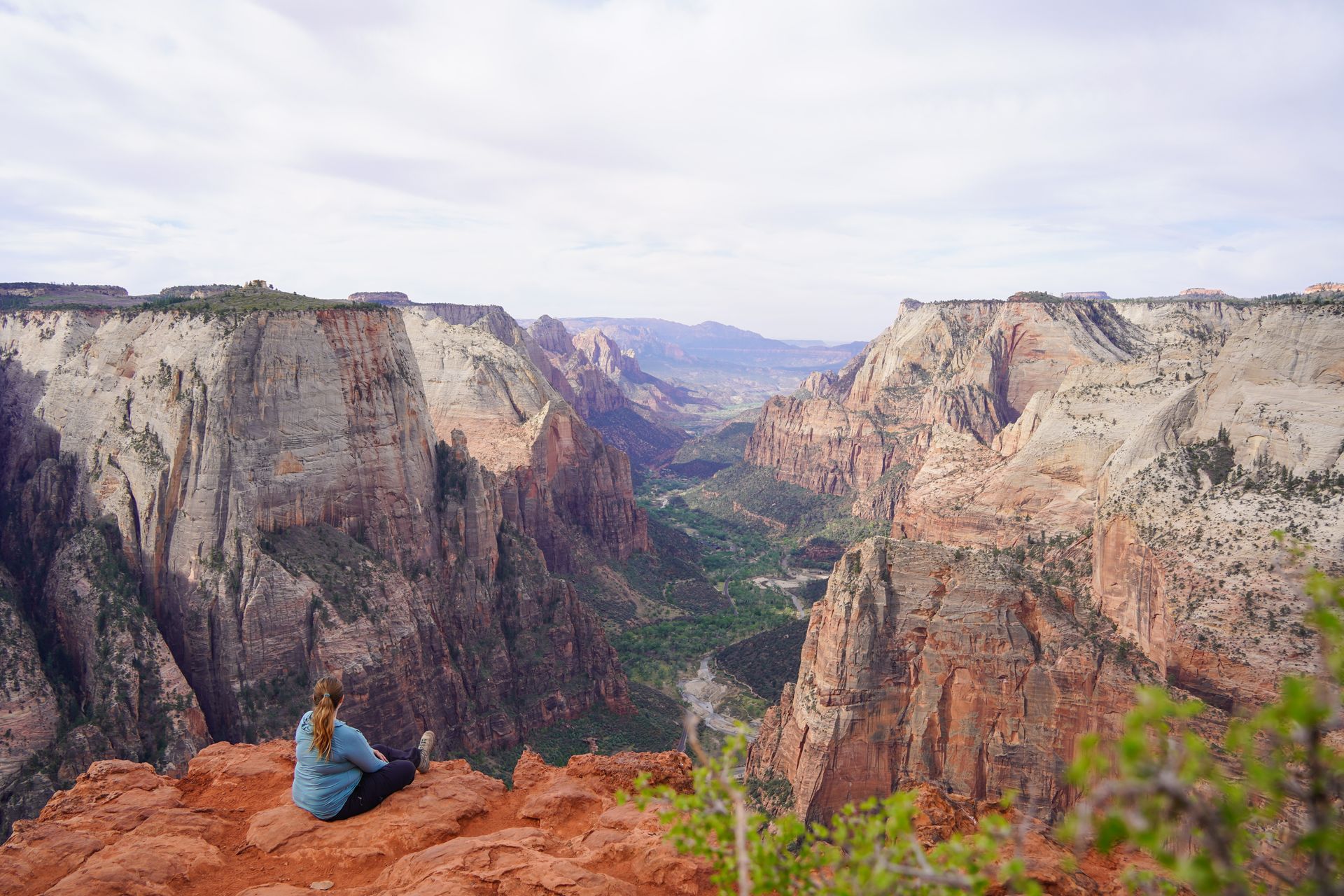 Lydia sitting on the edge of a cliff at Observation Point in Zion National Park