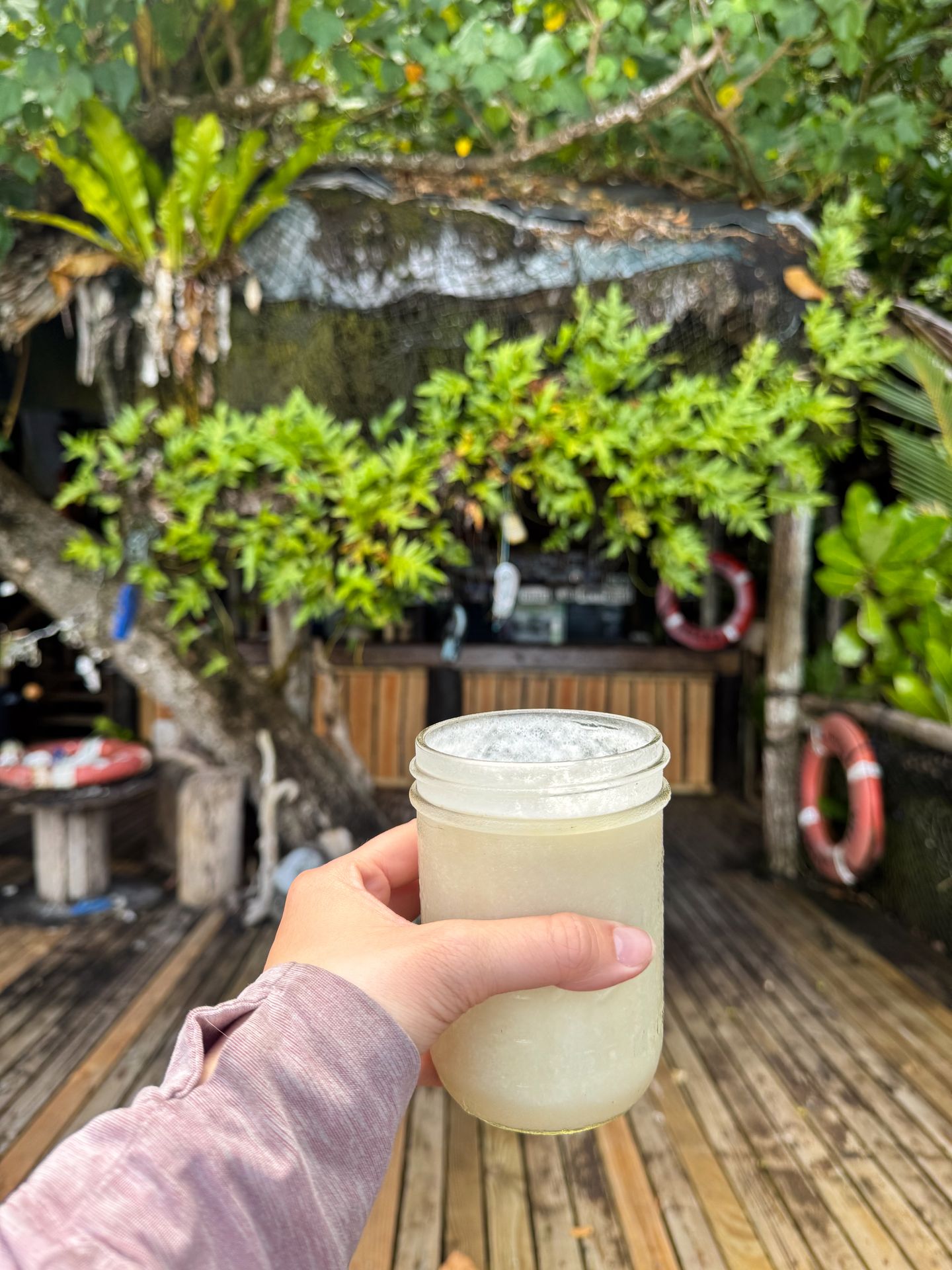 Holding up a pina colada at Tisa's Barefoot Bar