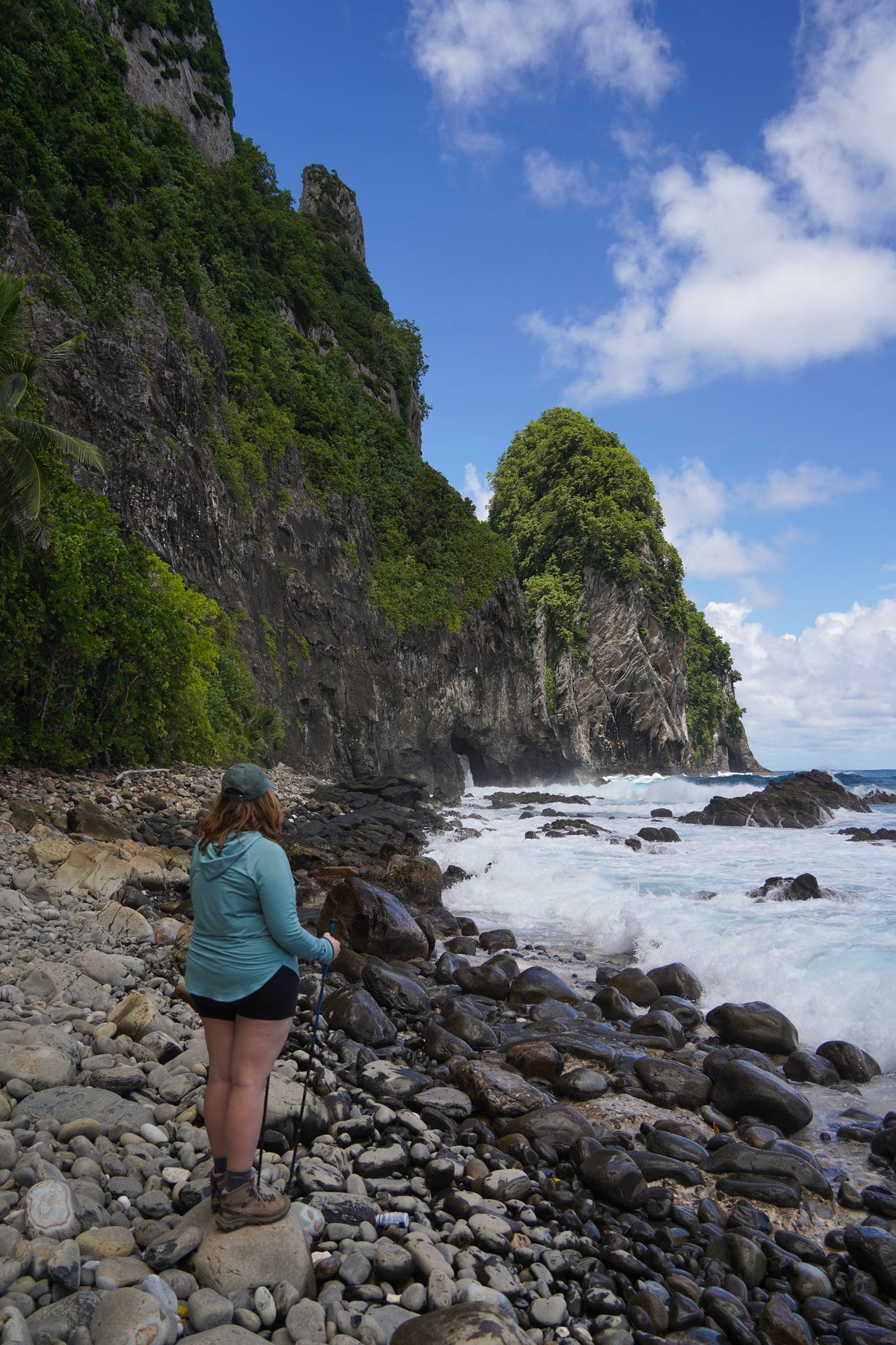 Lydia standing on the rocky beach and looking at Pola Island from the Pola Island Viewpoint