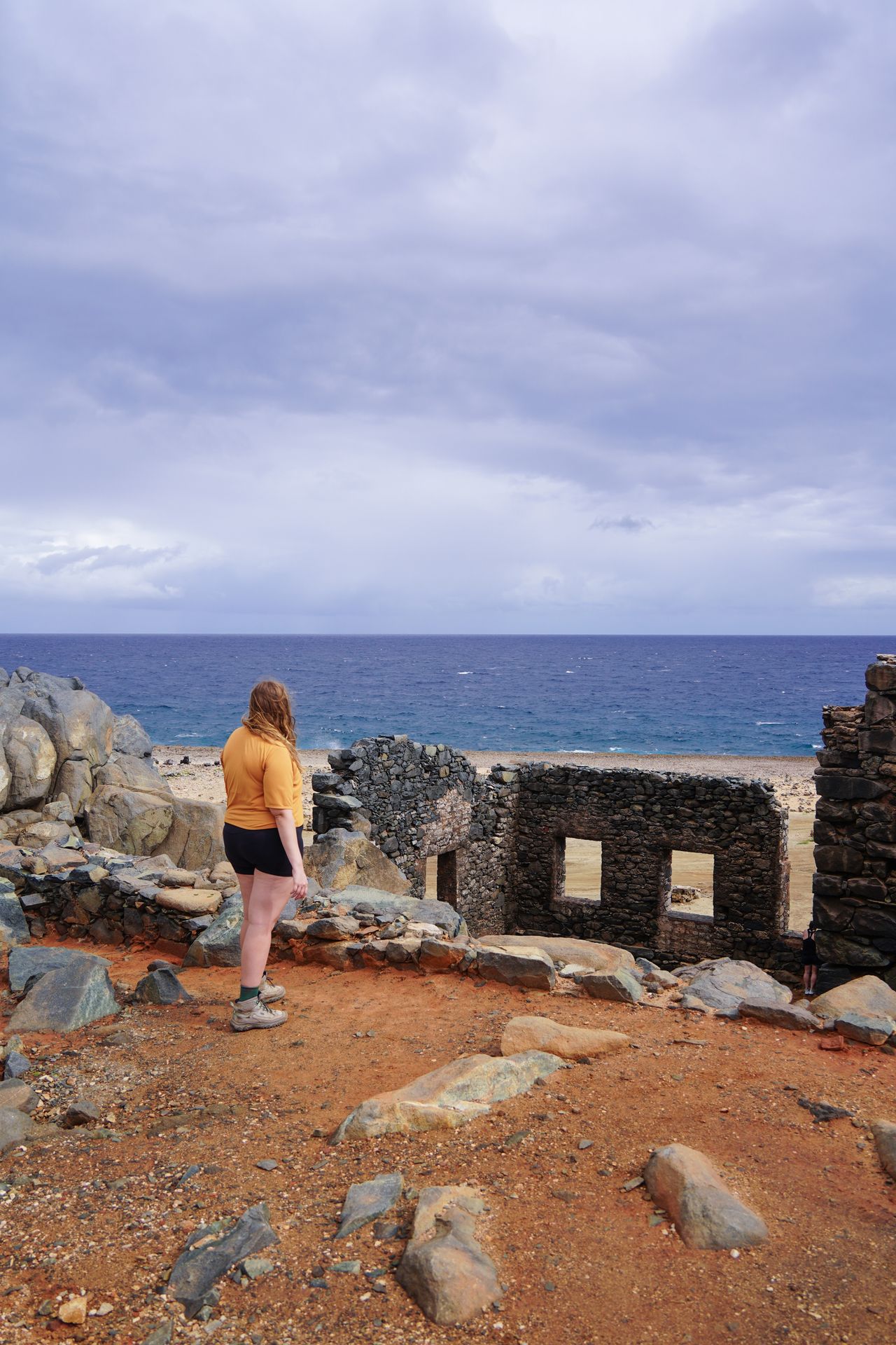 Lydia standing up above ruins