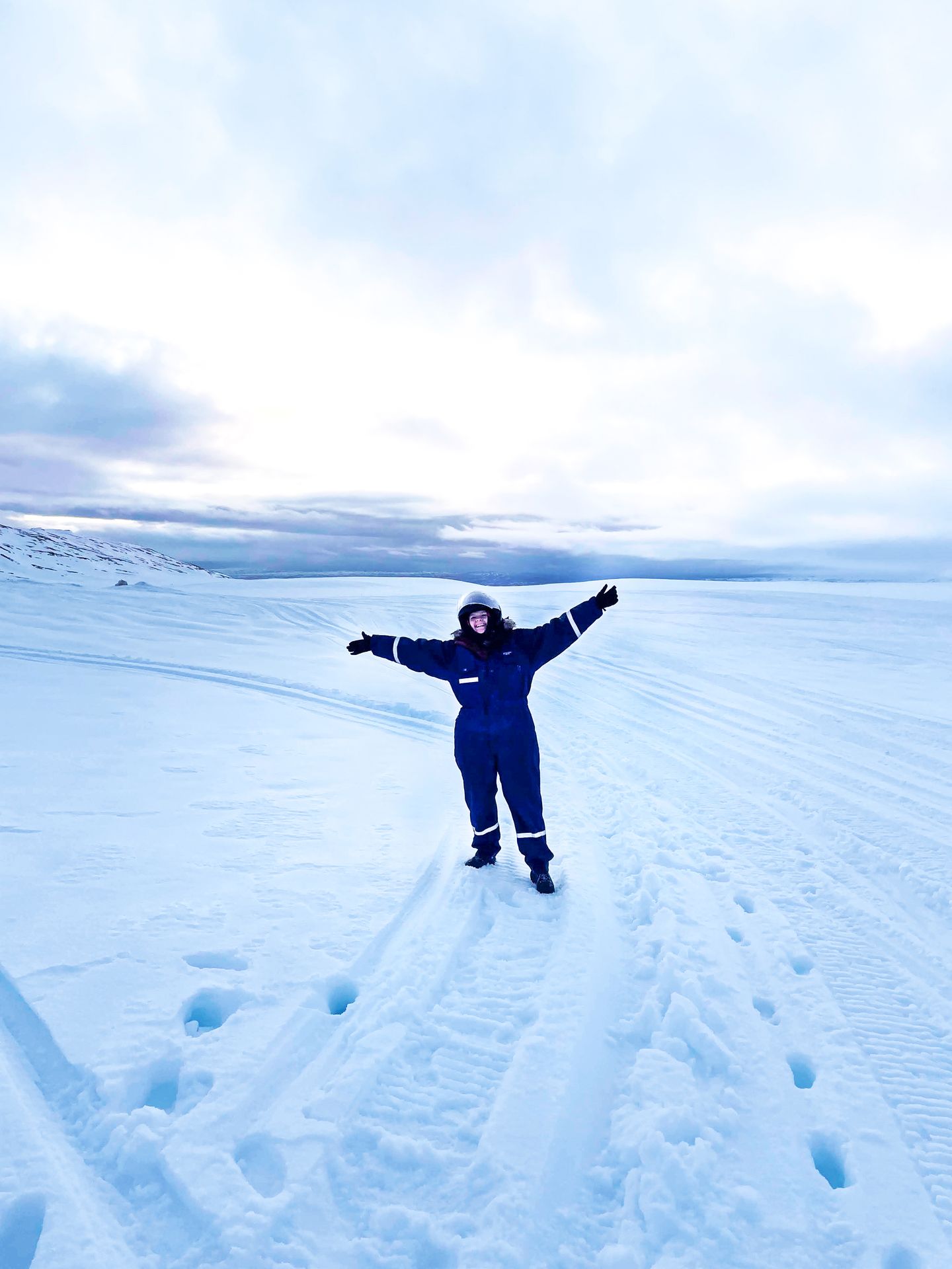 Lydia wearing a snow suit and walking on snow.