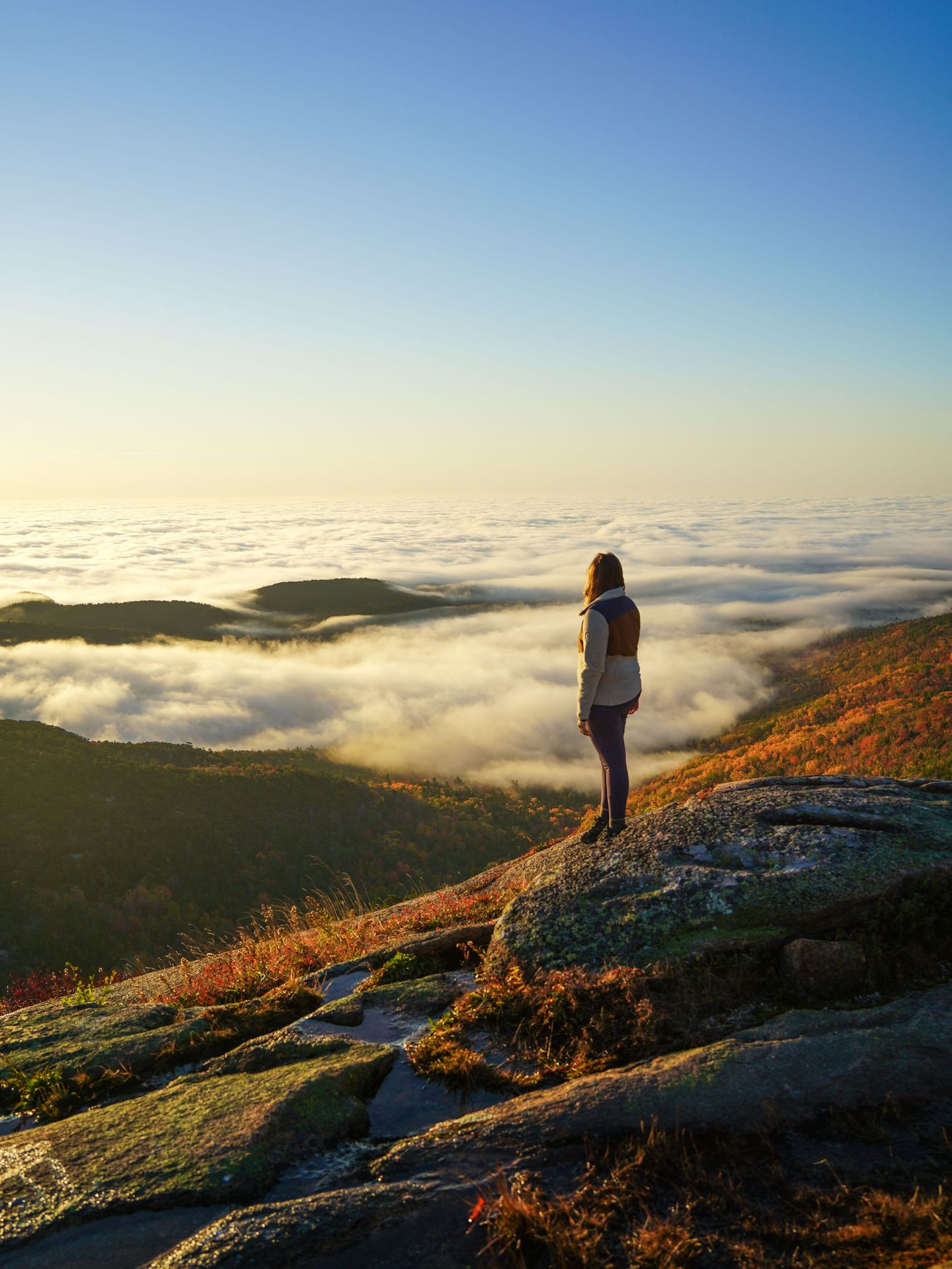 Lydia standing at watching the sunrise from Cadillac Mountain