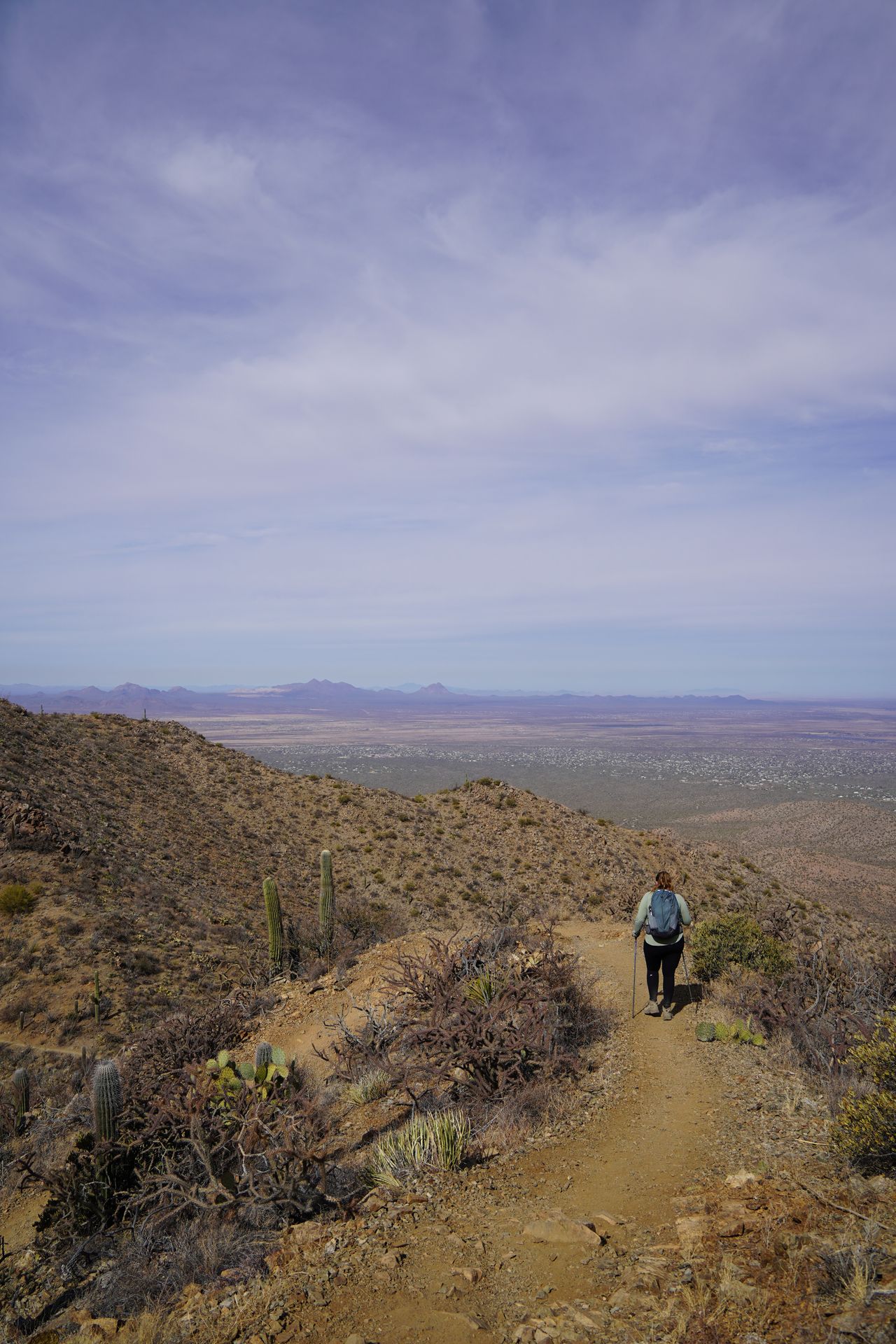 Lydia hiking on a trail with mountains surrounding her