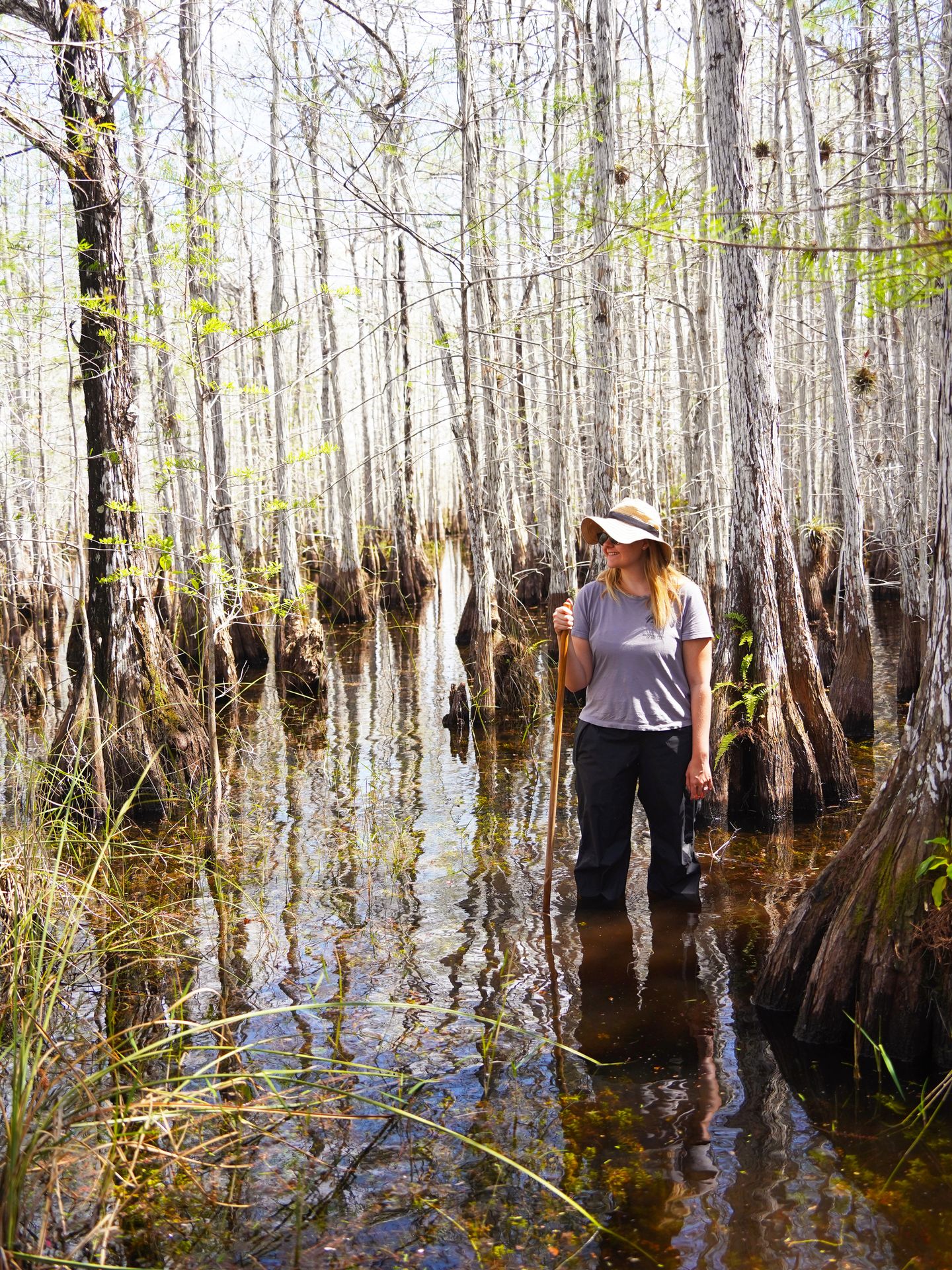 Lydia standing knee deep in water surrounded by white cypress trees